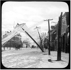 A street in Elora, Ontario after an ice storm - frozen utility lines are pulled over by weight of ice. (Photo captured between 1900 and 1919.)